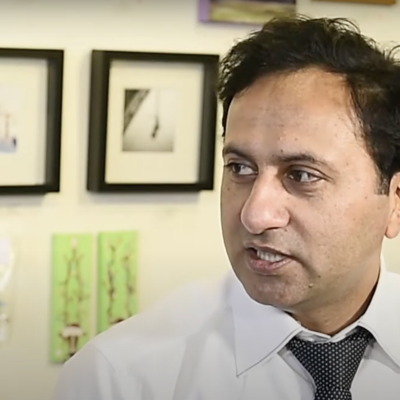 A photo of a person with short brown hair in a white shirt and tie.